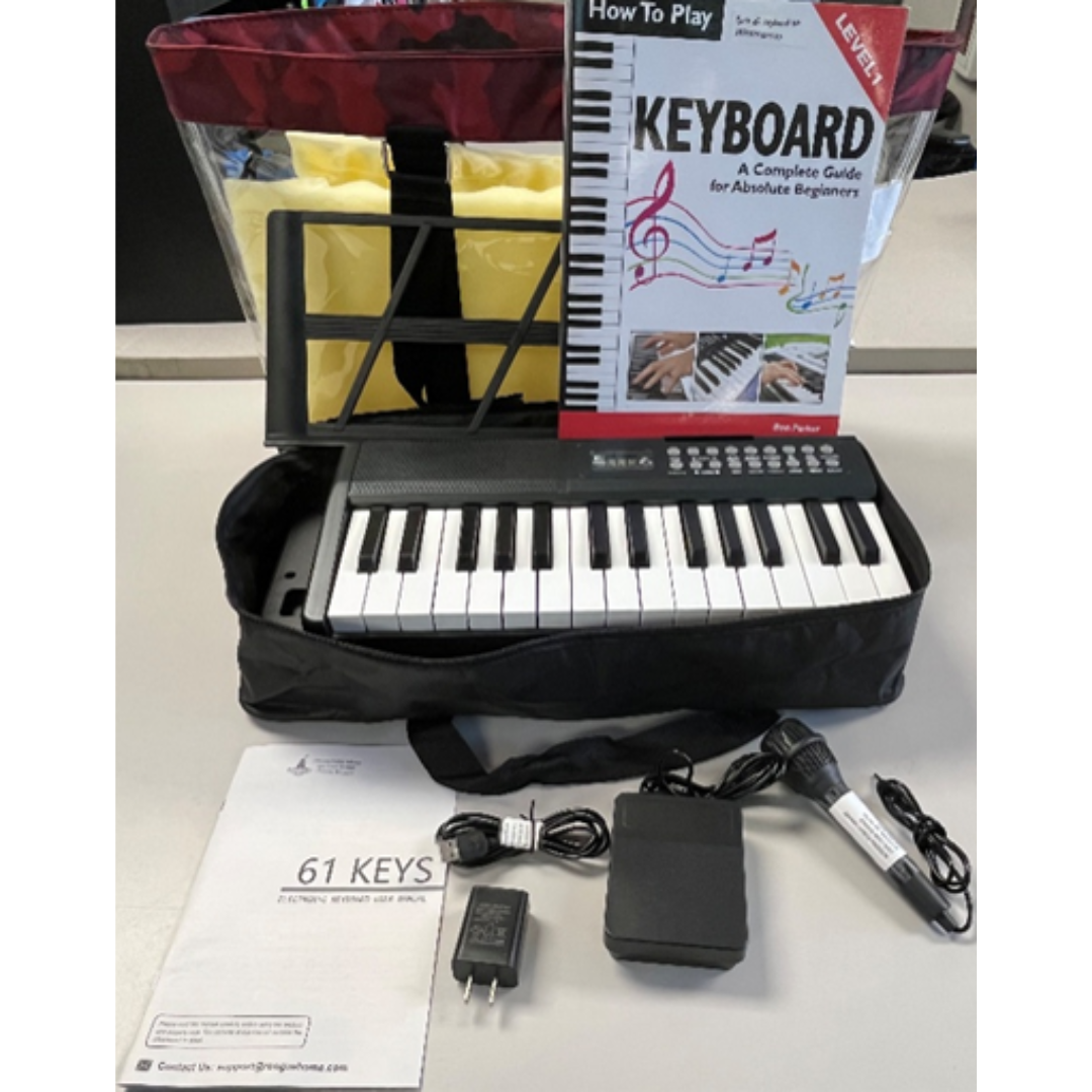 portable piano keyboard with supplies in front of it and clear bag behind